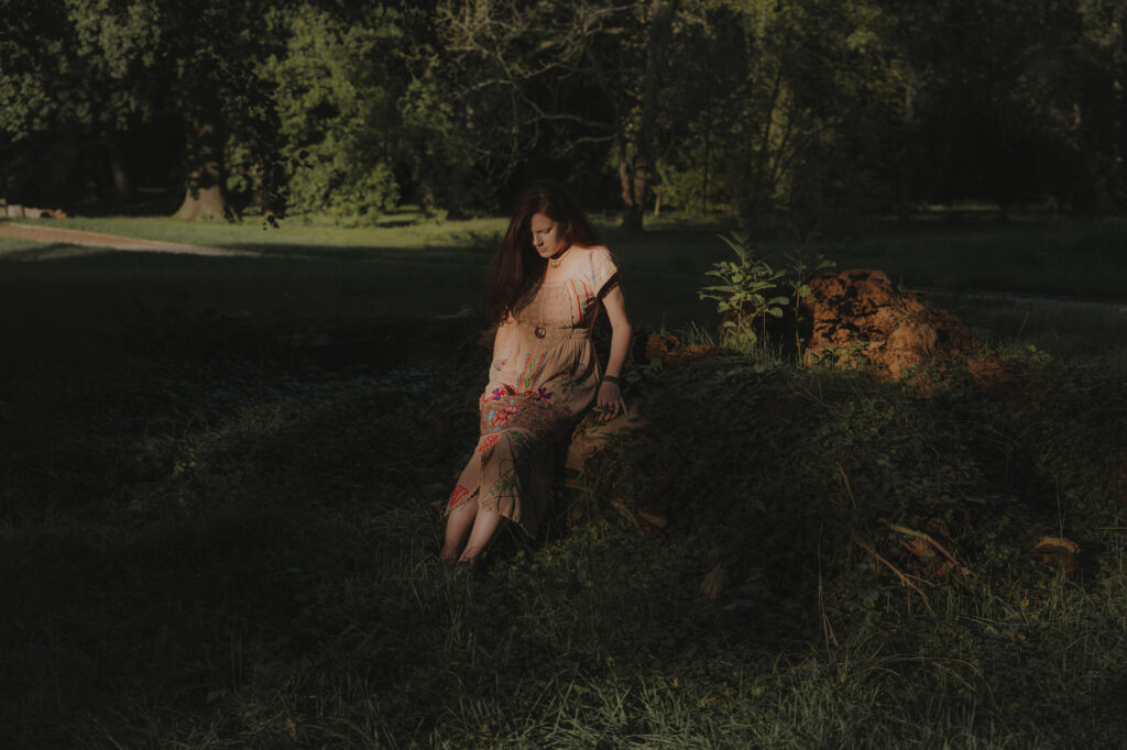 szamanka siedząca na zarośniętym pniu