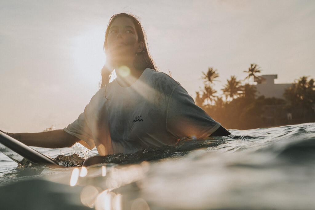 sri lanka - kobieta w oceanie na desce surfingowej