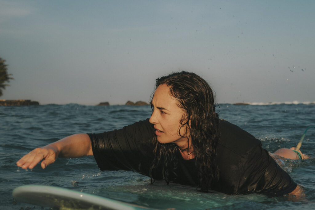 sri lanka - kobieta w oceanie na desce surfingowej