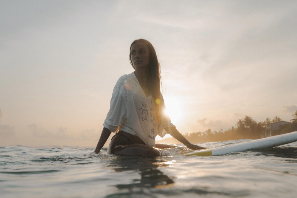 sri lanka - kobieta w oceanie na desce surfingowej