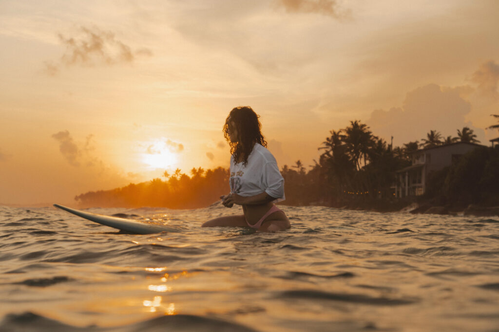sri lanka - kobieta w oceanie na desce surfingowej