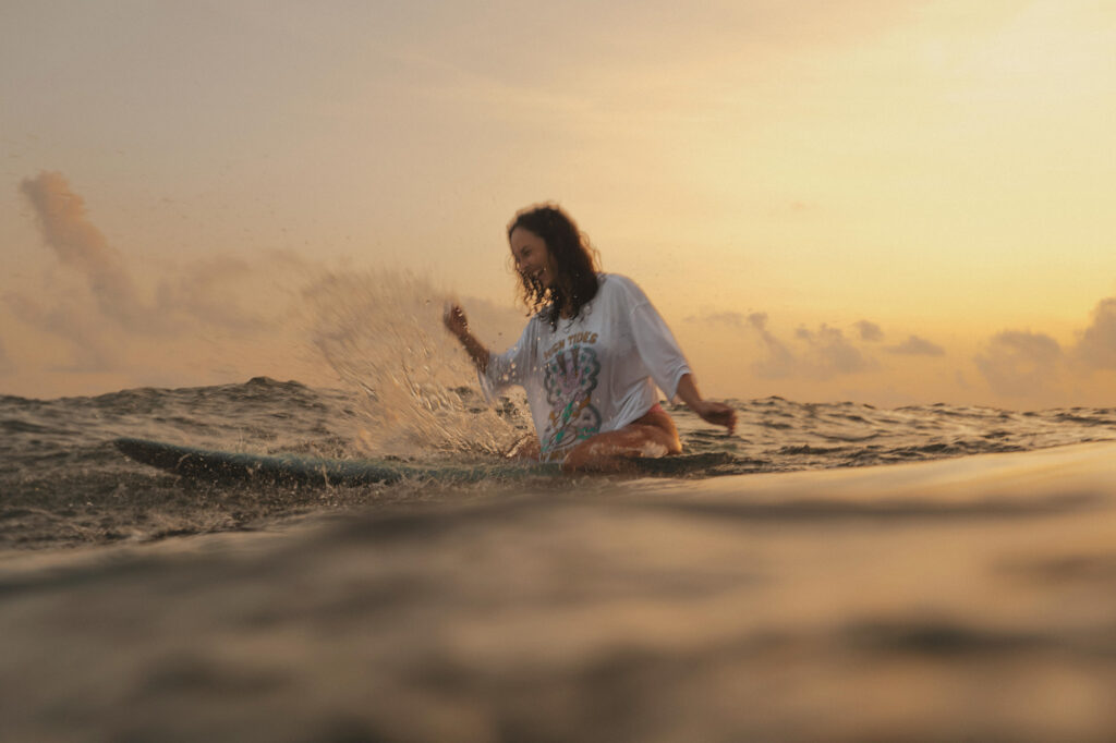 sri lanka - kobieta w oceanie na desce surfingowej