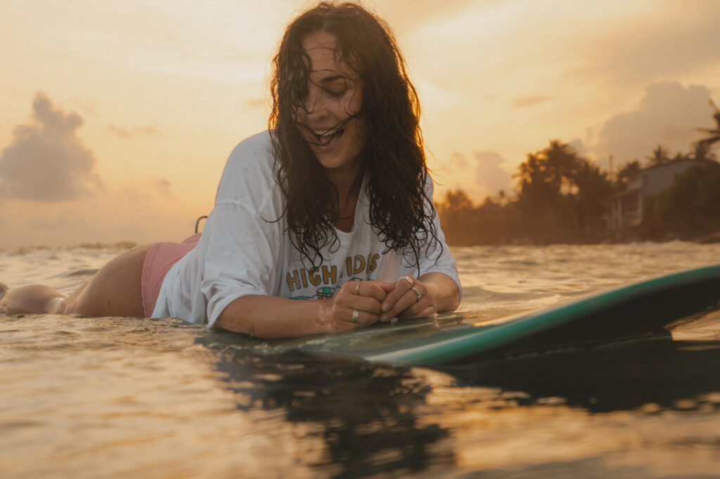 sri lanka - kobieta w oceanie na desce surfingowej