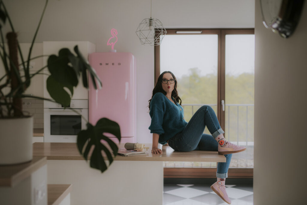 Autorka Astrokultury Agata siedząca na blacie w kuchni w otoczeniu prasy