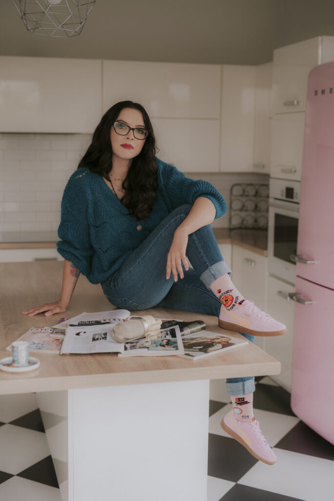 Autorka Astrokultury Agata siedząca na blacie w kuchni w otoczeniu prasy