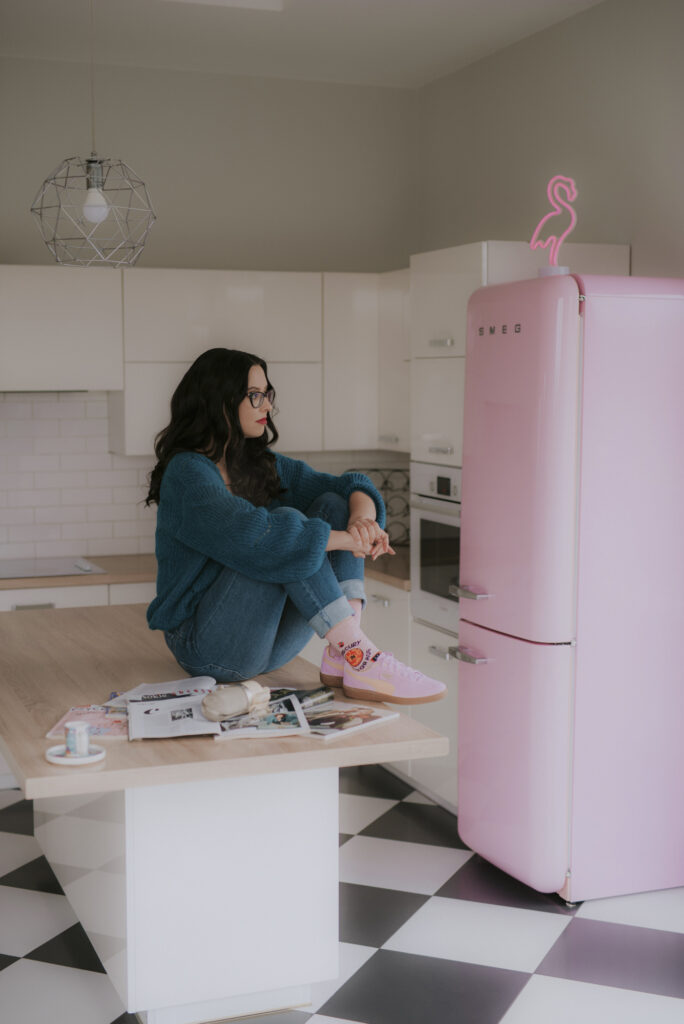 Autorka Astrokultury Agata siedząca na blacie w kuchni w otoczeniu prasy