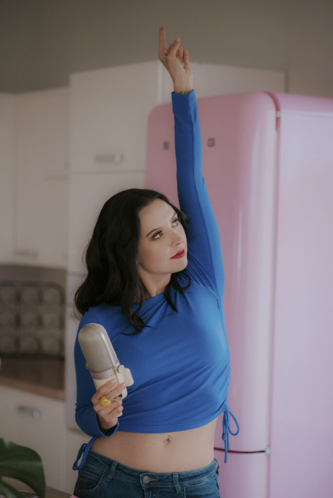 Astrolog Agata w niebieskim stroju z mikrofonem w dłoni - autorka Astrokultury