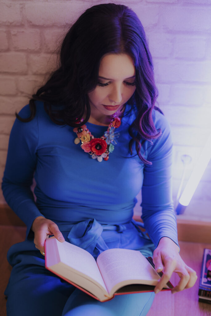 Astrolog Agata w niebieskim stroju czytająca książkę - autorka Astrokultury