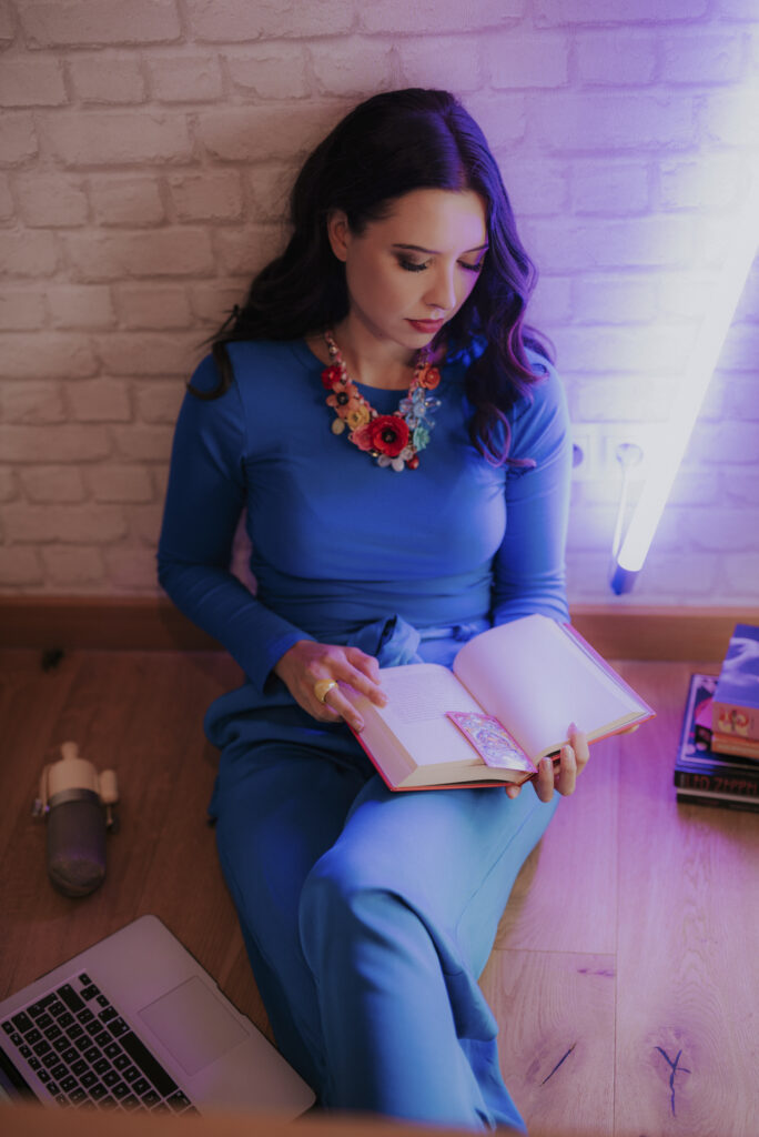 Astrolog Agata w niebieskim stroju czytająca książkę - autorka Astrokultury