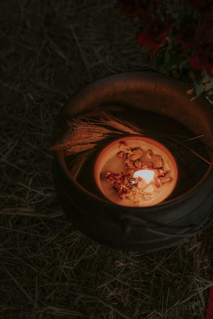 świecia z płatkami róż w żelaznym kociołku